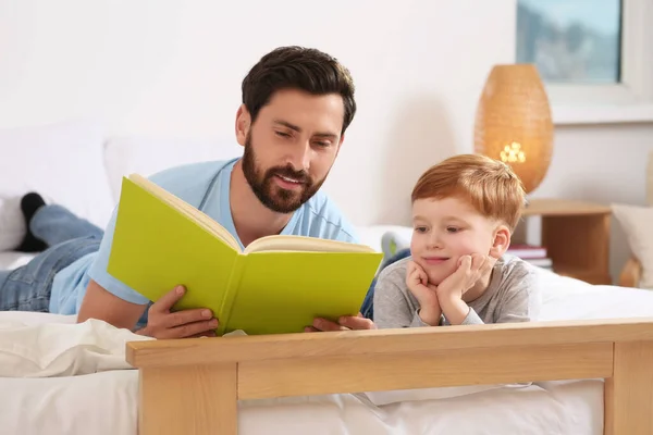 Отец Читает Книгу Своим Ребенком Постели Дома — стоковое фото