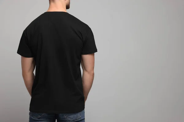 Mężczyzna Czarnej Koszulce Jasnoszarym Tle Widok Tyłu Makieta Projektowania — Zdjęcie stockowe