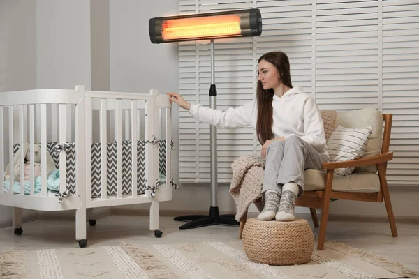 Mujer Joven Cerca Cuna Moderno Calentador Infrarrojos Eléctricos Interior — Foto de Stock