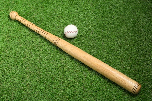 木制棒球棒和绿色草地上的球 俯瞰上方 体育设备 — 图库照片