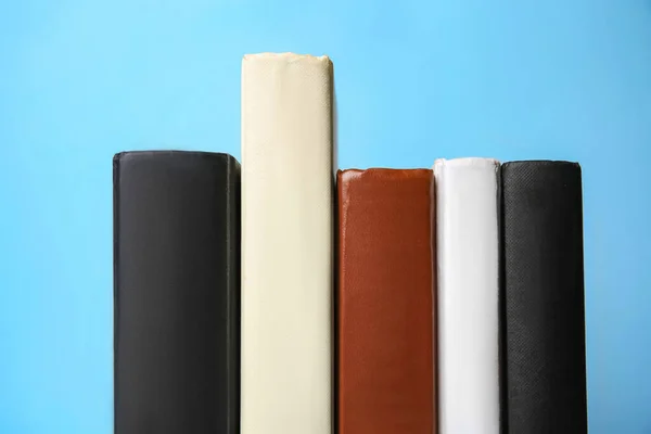 Collection of books on light blue background, closeup