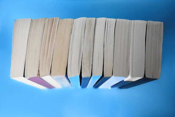 Collection of books on light blue background, above view