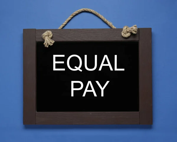 Blackboard with words Equal Pay on blue background, top view