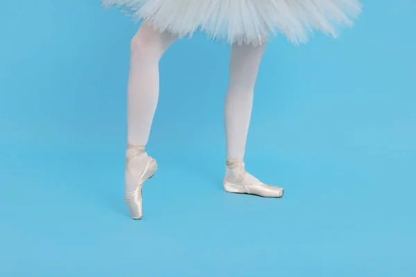 穿着尖皮鞋的年轻芭蕾舞演员在浅蓝色背景下练习跳舞 — 图库照片
