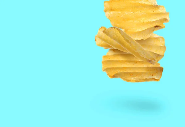Tasty Ridged Potato Chips Falling Cyan Background Space Text — Stock Photo, Image