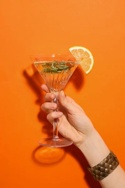 Žena Drží Martini Sklenici Osvěžující Koktejl Citrónem Plátkem Rozmarýnem Oranžovém — Stock fotografie