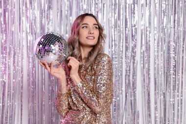 Partide disko topu olan altın elbiseli güzel bir kadın.