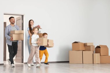 Yeni daireye kutular getiren mutlu bir aile. Eve yerleşmek.