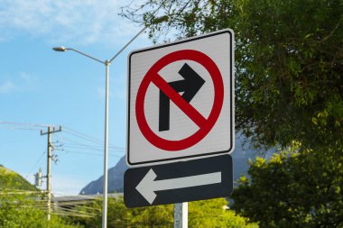 Different road signs on city street against blue sky