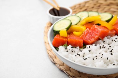 Delicious poke bowl with salmon, rice and vegetables on white table, closeup. Space for text clipart