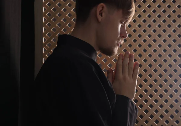Katolicki Ksiądz Modlący Się Przy Drewnianym Oknie Konfesjonale — Zdjęcie stockowe