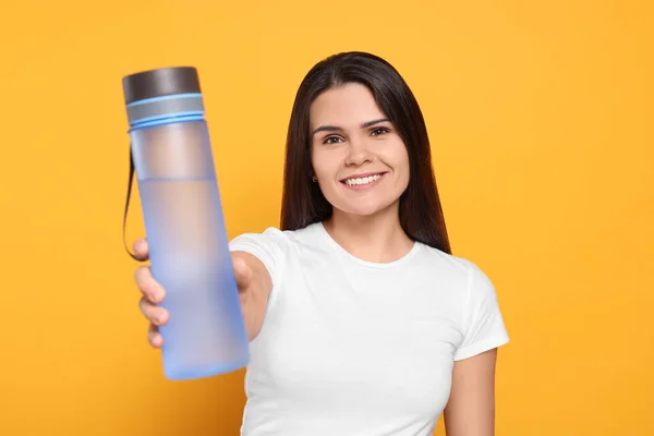 Mujer Joven Con Botella Agua Sobre Fondo Naranja —  Fotos de Stock