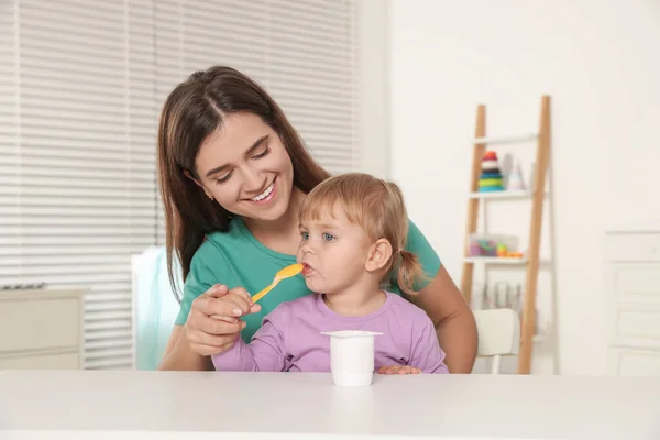 Annesi Beyaz Masada Yoğurtla Küçük Tatlı Çocuğunu Besliyor — Stok fotoğraf