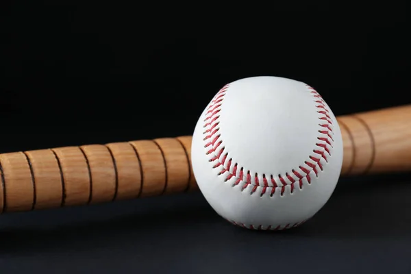 木制棒球棒和黑色背景的球 体育设备 — 图库照片