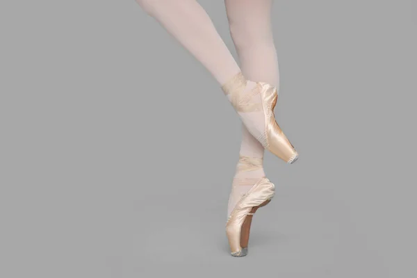 Молодая Балерина Пуантах Практикующая Танцевальные Движения Сером Фоне Крупным Планом — стоковое фото