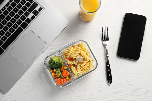 集装箱与美味的食物 一杯果汁 笔记本电脑 叉子和智能手机在白色木制桌子上 商务午餐 — 图库照片