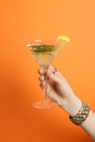 Žena Drží Martini Sklenici Osvěžující Koktejl Citrónem Plátkem Rozmarýnem Oranžovém — Stock fotografie