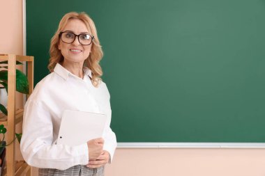 Happy professor with glasses near green board, space for text