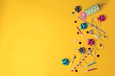 Turuncu arka planda konfeti, hava üfleyici ve şenlikli bir dekor. Metin için boşluk