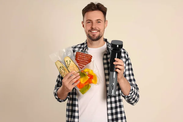 Чоловік Тримає Відео Плиту Різні Продукти Харчування Вакуумних Упаковках Бежевому — стокове фото