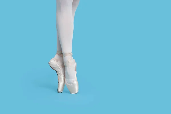穿着尖皮鞋的年轻芭蕾舞演员在浅蓝色背景下练习跳舞 案文的篇幅 — 图库照片