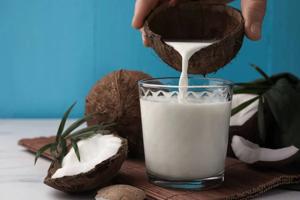 Mujer Vertiendo Deliciosa Leche Coco Vidrio Mesa Mármol Blanco Primer — Foto de Stock