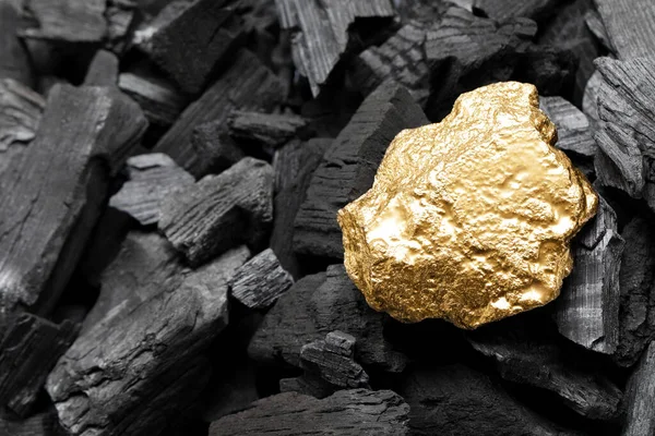 stock image Shiny gold nugget on coals, closeup view