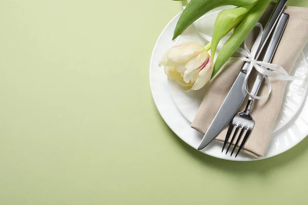 薄緑色の背景に刃物とチューリップでスタイリッシュなテーブルセッティング トップビュー テキストのスペース — ストック写真