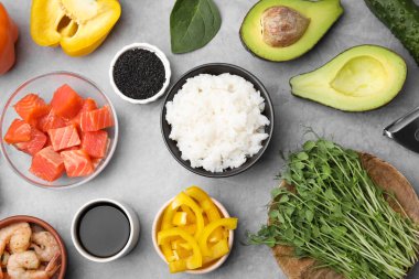 Ingredients for poke bowl on grey table, flat lay