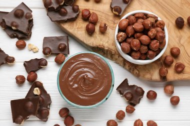 Lezzetli macun, çikolata parçaları ve fındıklar beyaz ahşap masada, düz yatıyordu.