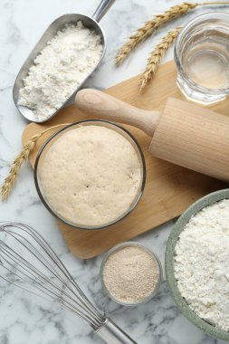 Yaprak, un, buğday kulakları, mermer masa üzerinde merdane, çırpı ve su, düz yatıyordu.