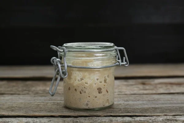 Stock image Leaven in glass jar on wooden table