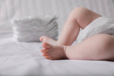 Little baby in diaper lying on bed, closeup