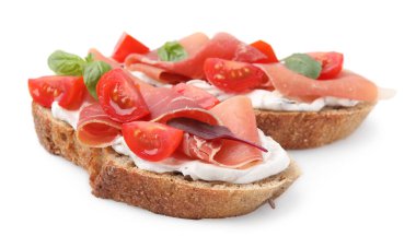 Beyaz arka planda jambonlu, domatesli ve peynirli lezzetli bruschettalar.