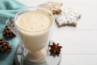 Lezzetli eggnog, kurabiyeler ve beyaz ahşap masada anason yıldızı, yakın plan. Metin için boşluk