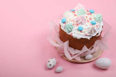 Traditional Easter cake with meringues and painted eggs on pink background, space for text