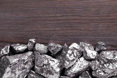 Pile of silver nuggets on wooden table, flat lay. Space for text