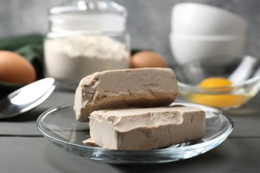 Sıkıştırılmış maya, yumurta ve un gri masada.