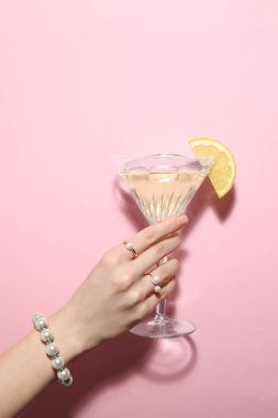 Elinde taze limon dilimli martini bardağı tutan kadın, yakın plan.