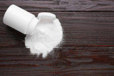 Siyah ahşap masanın üstünde tatlı pudralı früktoz kavanozu, üst manzara. Metin için boşluk