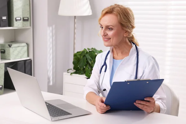Läkare Med Laptop Och Urklipp Vid Vitt Bord Kliniken Patientsamråd — Stockfoto