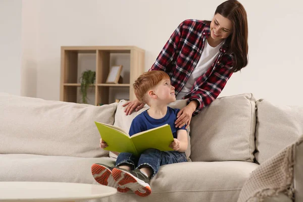 快乐的母亲和她的孩子在家里看书 给他们留点文字空间 — 图库照片