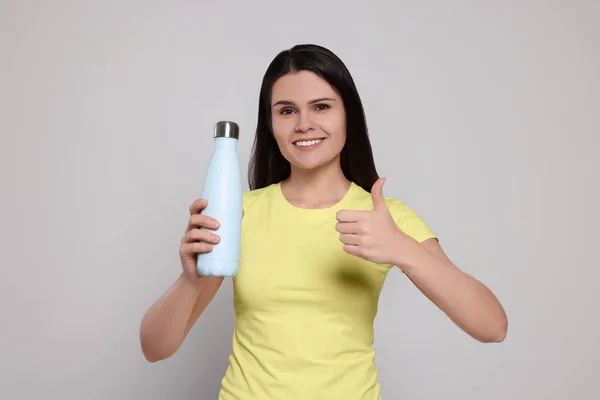 Junge Frau Mit Thermoflasche Auf Hellgrauem Hintergrund — Stockfoto