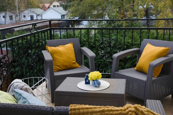 stock image Orange pillows and yellow chrysanthemum flowers on rattan garden furniture outdoors