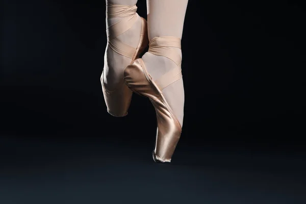 芭蕾舞女演员穿着尖皮鞋 在黑色背景下跳舞 — 图库照片