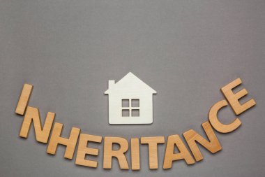 Ahşap harflerle ve gri arka planda ev modeliyle yapılmış bir miras. Metin için boşluk