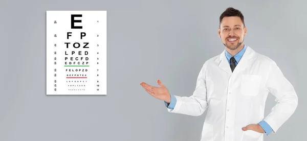Prueba Visión Oftalmólogo Optometrista Apuntando Carta Ocular Sobre Fondo Gris — Foto de Stock