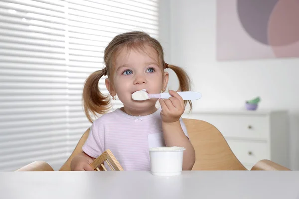 Bambino Carino Mangiare Gustoso Yogurt Tazza Plastica Con Cucchiaio Tavolo — Foto Stock