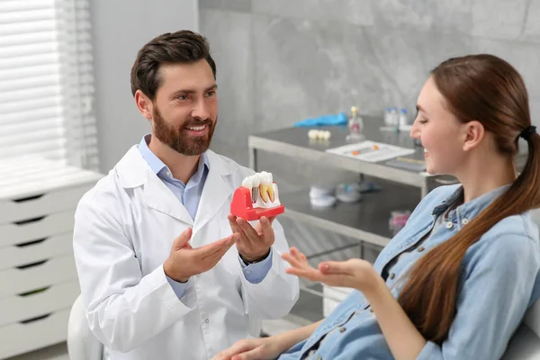 臨床における歯科インプラントコンサルティング患者の教育モデルを持つ医師 — ストック写真