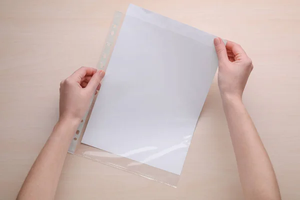 Vrouw Met Geperforeerde Zak Met Papieren Blad Aan Houten Tafel — Stockfoto